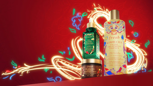 Fresh brand beauty product presentation on a red background with golden decorative swirls and floral accents. Three product sizes.