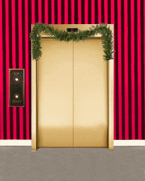 Closed metallic gold elevator doors decorated with a green pine garland against red and black striped wallpaper
