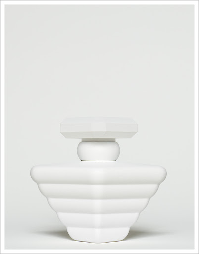 Elegant, all-white perfume bottle on a white background, showcasing its unique tiered design and smooth finish, emphasizing simplicity and style.