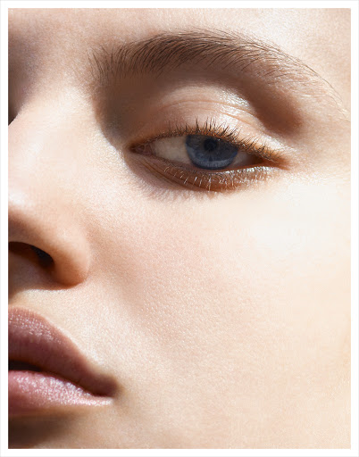 Close-up portrait of a woman's face highlighting her blue eye and natural skin texture captured by photographer Kutlu.