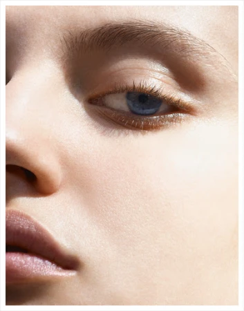 Close-up portrait of a woman's face highlighting her blue eye and natural skin texture captured by photographer Kutlu.