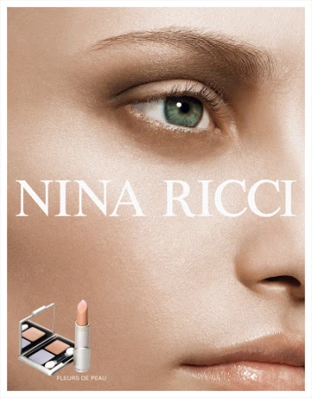 Close-up of woman's face in beauty ad for Nina Ricci, featuring lipstick and makeup palette, emphasizing natural skin tones and textures.