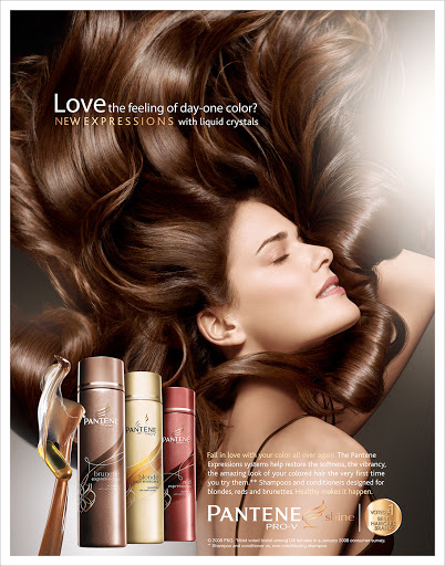 Beauty ad featuring a woman with brown hair, soft lighting, and Pantene hair product bottles in the foreground against a dark background.
