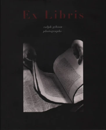 Monochrome book cover featuring hands holding open a heavy medieval manuscript with dense handwritten text under red title lettering.