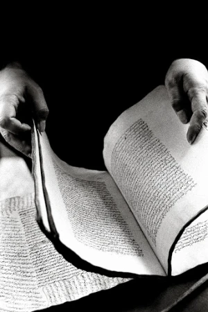 Close-up of hands turning the pages of an old handwritten manuscript in high contrast black and white photography by Ralph Gibson.