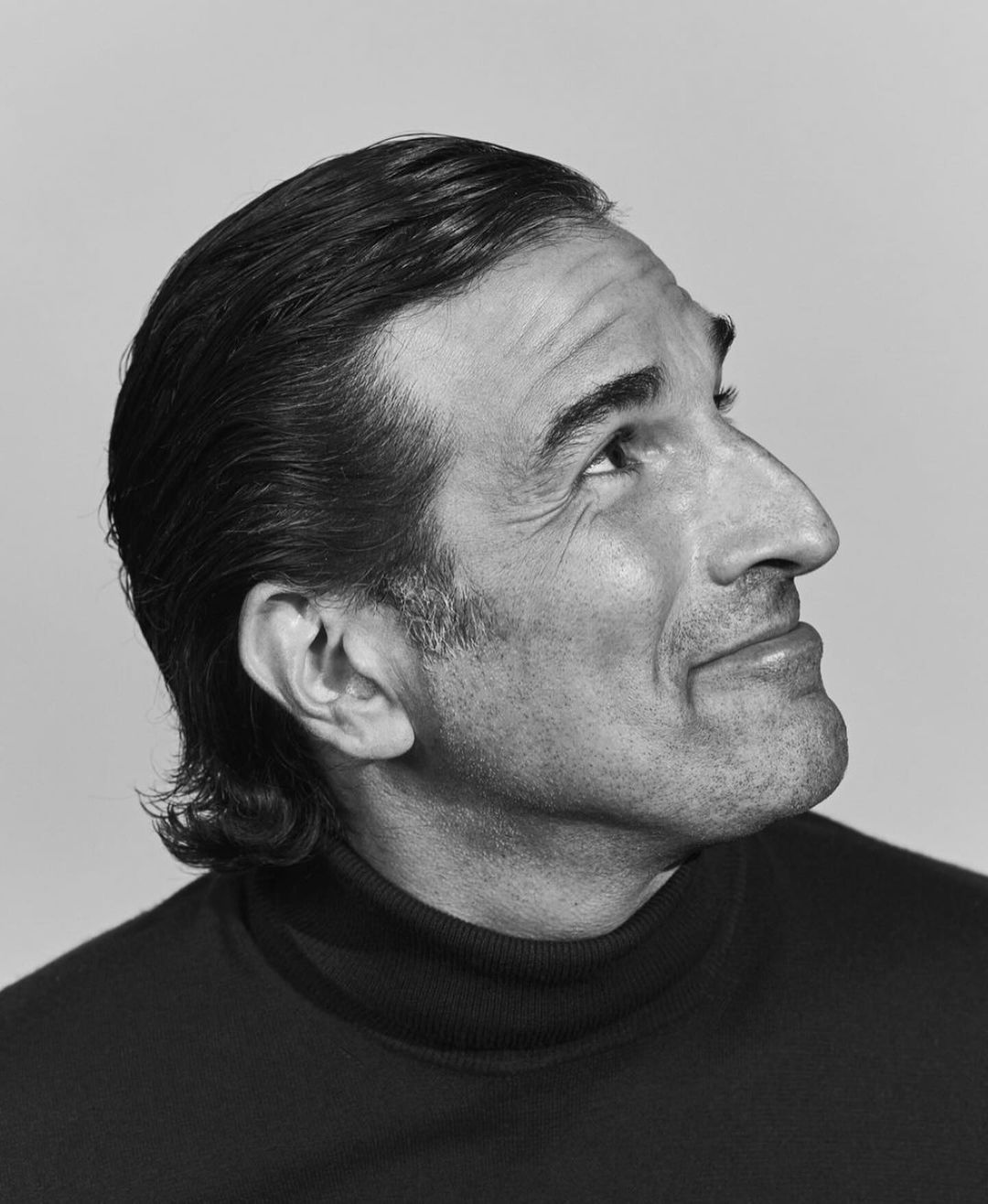 Monochrome portrait of a man in a black turtleneck looking upwards by Aaron Richter