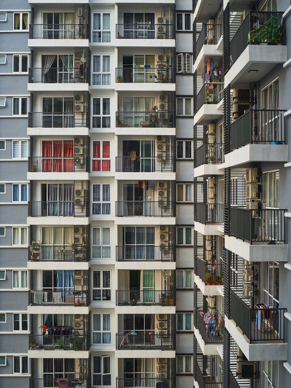 Exterior facade of a modern multi-story residential apartment building with balconies and large windows photographed by Aaron Richter.