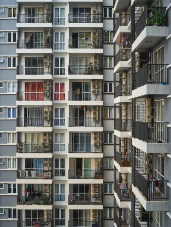 Exterior facade of a modern multi-story residential apartment building with balconies and large windows photographed by Aaron Richter.