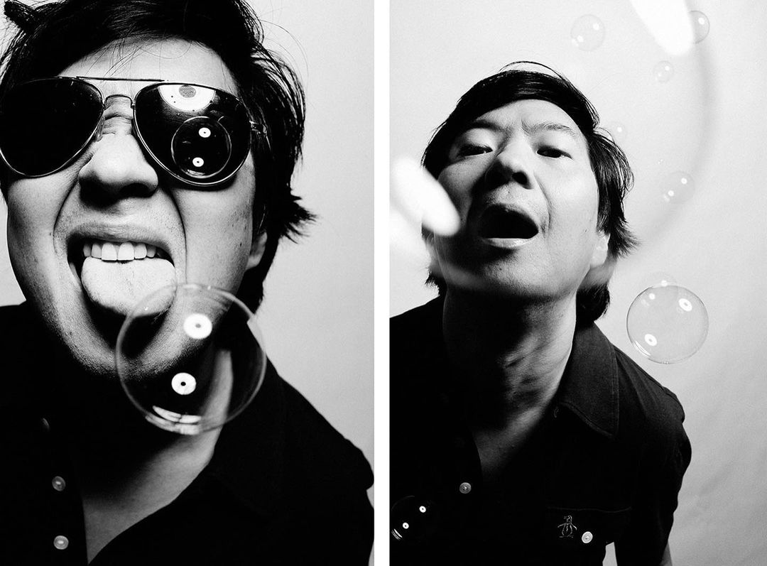 Monochrome portrait of a man in sunglasses blowing bubbles, captured in a dual-image format against a bright, neutral backdrop.