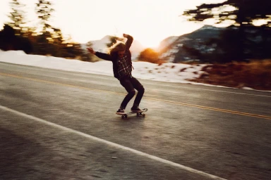 Skater riding down an empty asphalt road at sunset with motion blur, captured by Bryan Sheffield in Los Angeles.