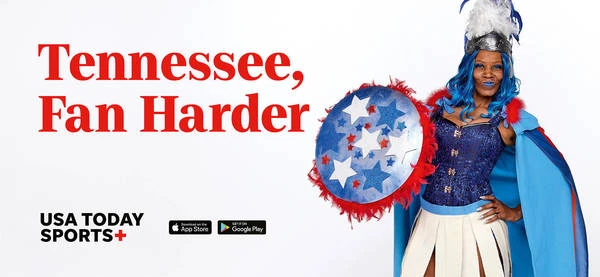 Adult woman wearing a patriotic sports fan costume and shield poses in a studio against a white background for USA Today Sports+.