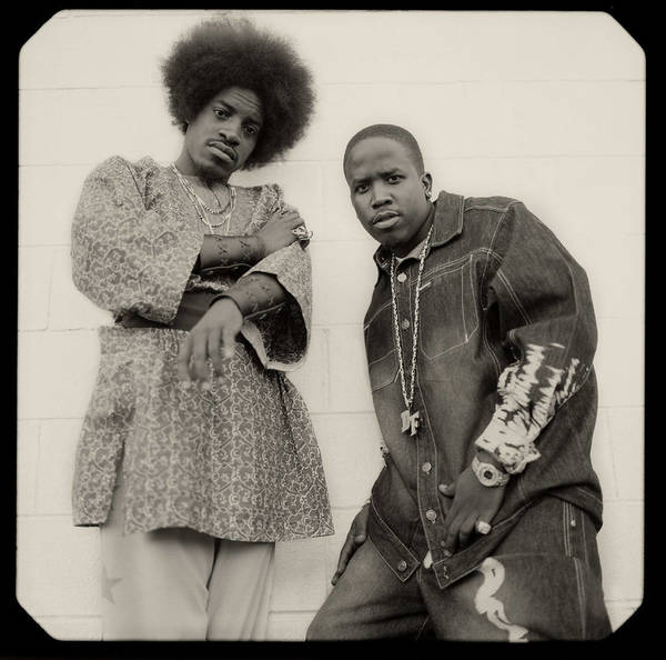 Portrait of André 3000 and Big Boi of Outkast posing outdoors against a plain tiled wall, photographed by Joseph Cultice.