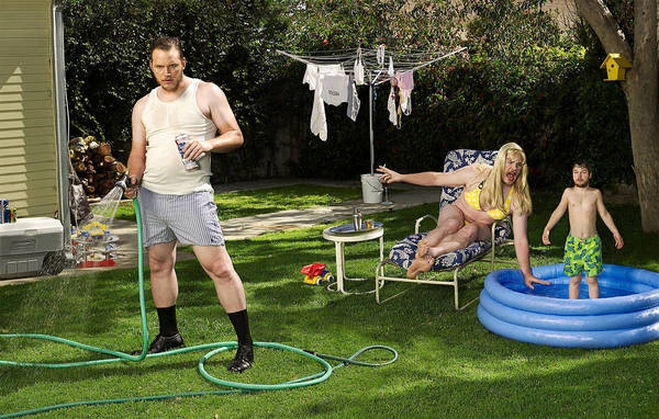 Outdoor summer scene featuring an adult male with a beer and water hose, woman in a swimsuit on a lounge chair, and a child in a pool.