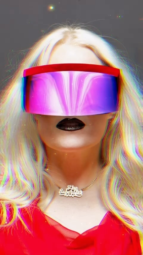 Person with blonde hair wearing a red top and futuristic purple visor-like sunglasses, against a grey background with light effects.