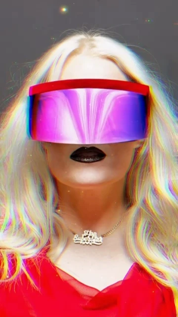 Person with blonde hair wearing a red top and futuristic purple visor-like sunglasses, against a grey background with light effects.