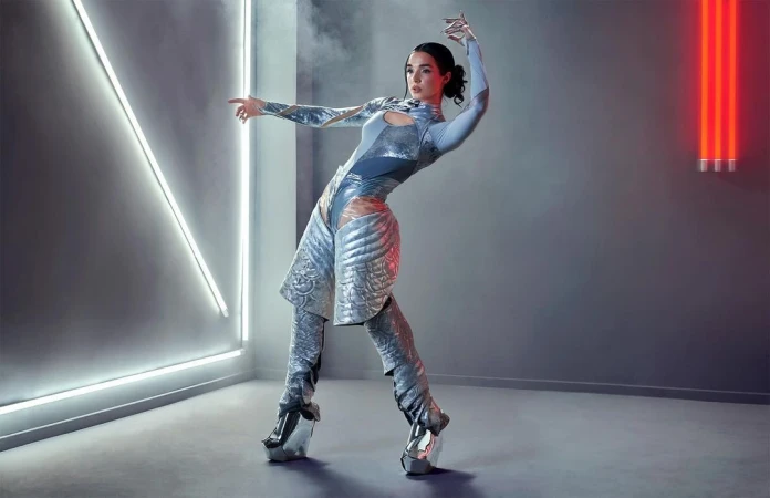 A woman in a futuristic bodysuit and platform shoes poses in a studio with white and red neon lights, creating a dynamic and visually striking image.