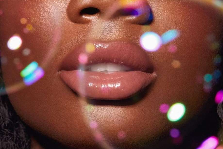 Close-up macro shot of glossy lips with iridescent bokeh light effects captured by Nathalie Gordon