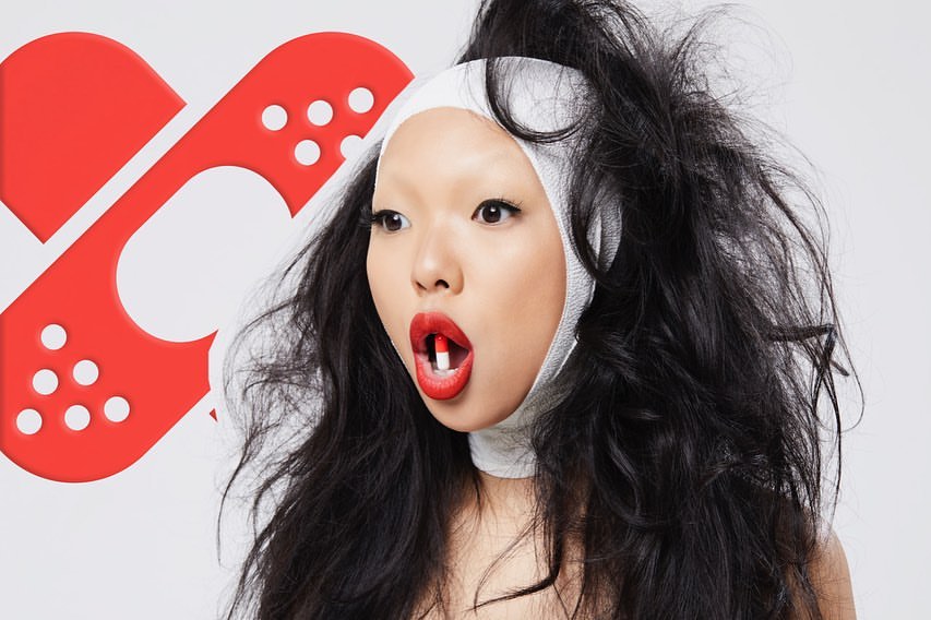 Asian woman with capsule pill, red lipstick, and white bandage headband against a white background with a red bandage graphic.