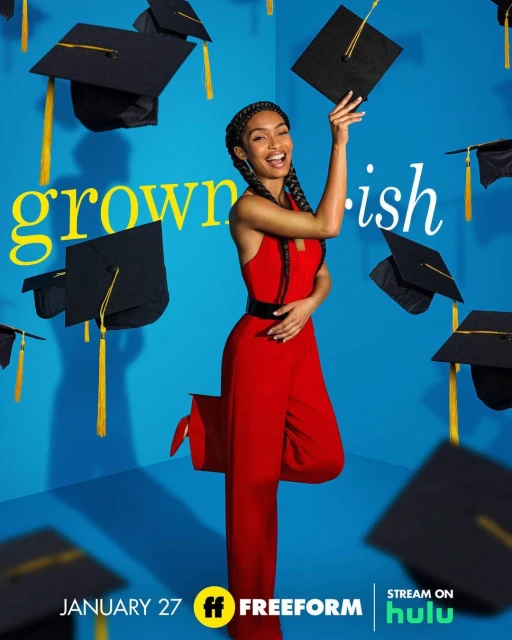Yara Shahidi in a red jumpsuit smiles in a promotional image for Grown-ish, surrounded by floating graduation caps on a blue backdrop.
