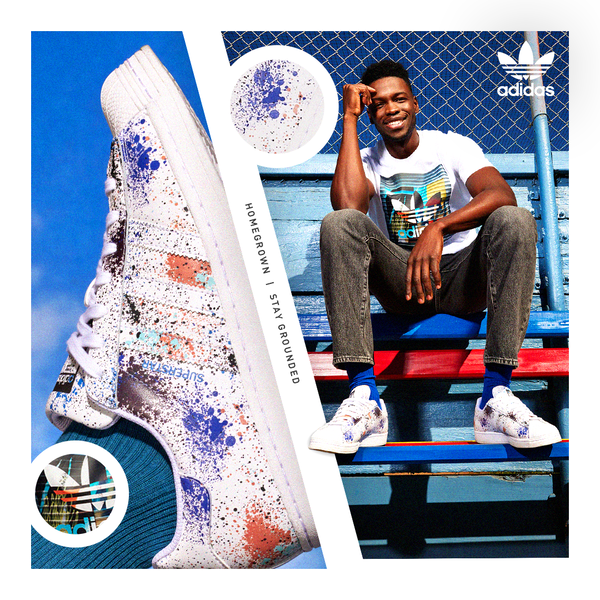 Promotional shot: white Adidas Superstar sneaker with paint splatter beside an adult male wearing same sneakers sitting on bleachers.
