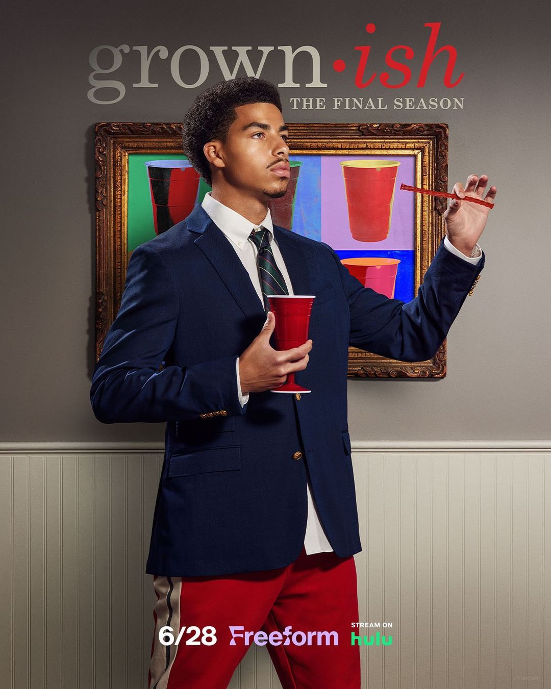 Actor poses with a red cup on the Grown-ish TV show poster, featuring text, red solo cups in the background art, and a blue blazer.