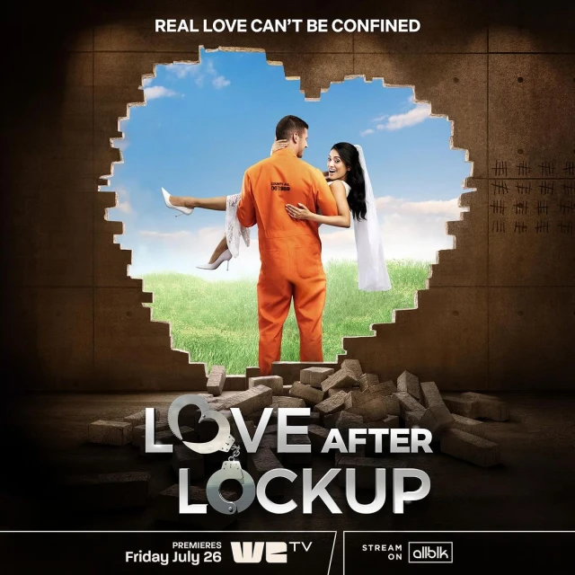 A man in an orange prison jumpsuit carries a woman in a white wedding dress out of a heart-shaped hole in a concrete wall.