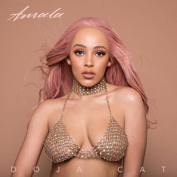 Glamorous portrait of Doja Cat with pink hair, wearing a diamond-studded bikini top and necklace against a neutral background for her album cover.