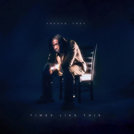 Darkly lit album cover featuring a young Black male artist seated on a wooden chair against a dark blue gradient background.