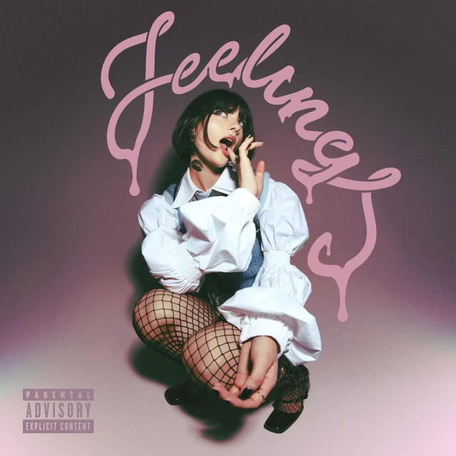Young woman with bob haircut in fishnet stockings and white ruffle blouse posing in studio with 'Feeling' text design and parental advisory logo.