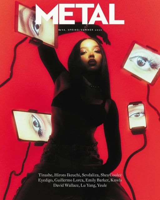 Magazine cover featuring a woman in a black crop top, surrounded by eye images on screens, against a vibrant red backdrop.