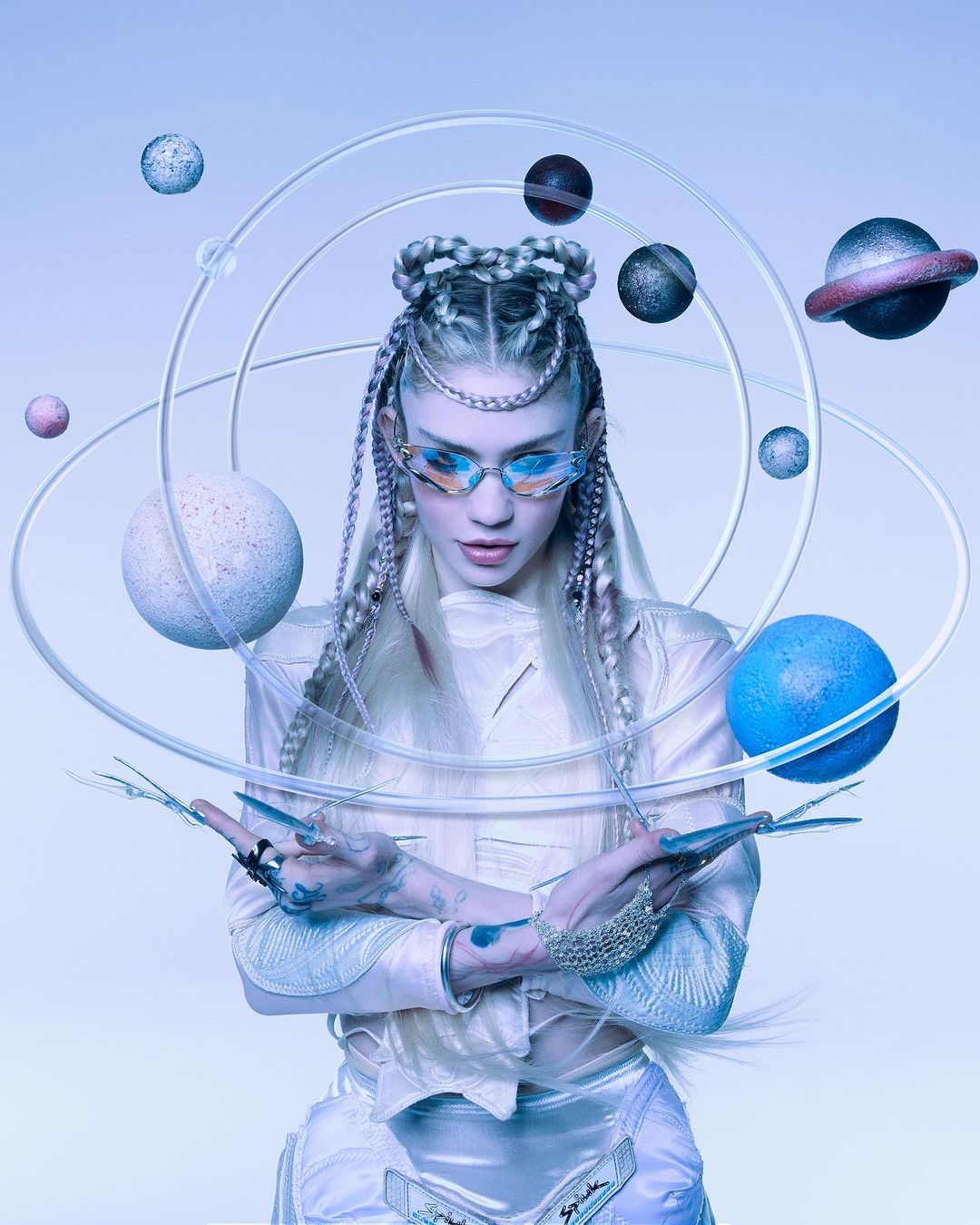 A person with unique hair and glasses poses with planets in an ethereal studio setting, creating a visually striking and artistic portrait.