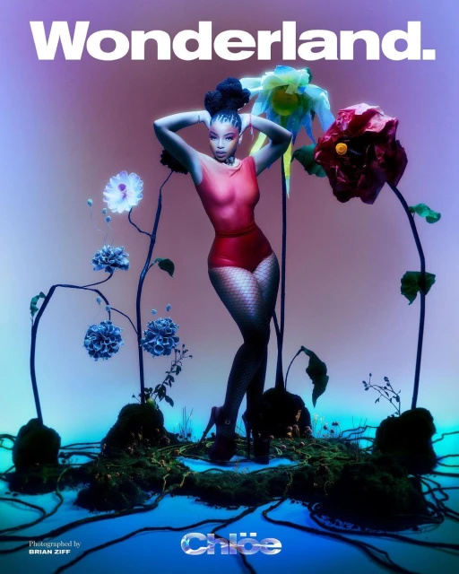 Chlöe Bailey poses in a red bodysuit and black fishnet stockings with an elaborate updo, surrounded by colorful flowers in a surreal setting.