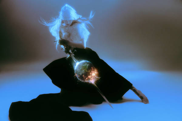 Female figure in a draped head covering and dark robe holds a sword pointed at a glowing, fiery globe in a mystical indoor setting.
