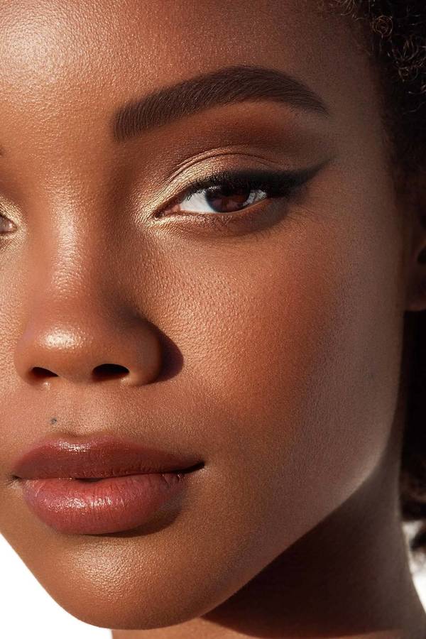Close-up beauty portrait of a Black woman with gold eyeshadow and winged eyeliner by photographer Brian Ziff