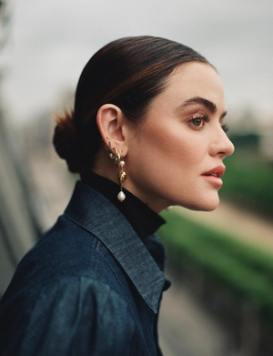 Profile portrait of a woman wearing a dark denim jacket and gold pearl drop earrings photographed by Claire Leahy.