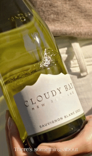 Close up of a person holding a chilled bottle of Cloudy Bay Sauvignon Blanc 2022 wine, with the brand label prominently displayed.