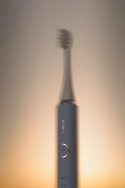 Electric toothbrush in a studio setting with soft lighting showcasing a toothbrush, hygiene, and oral care for product advertising.