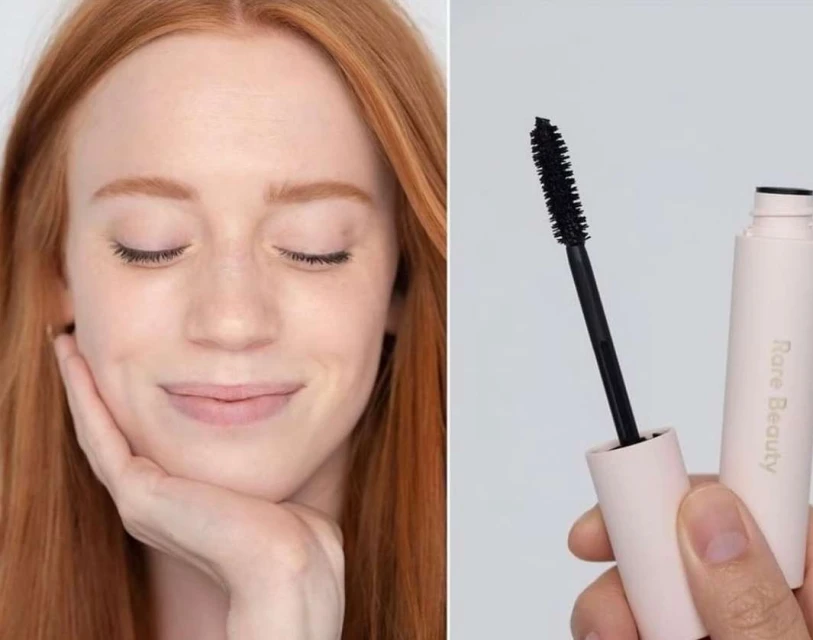 Redhead woman with eyes closed poses next to mascara. Makeup for beauty concept in soft studio lighting; fashion and cosmetics.