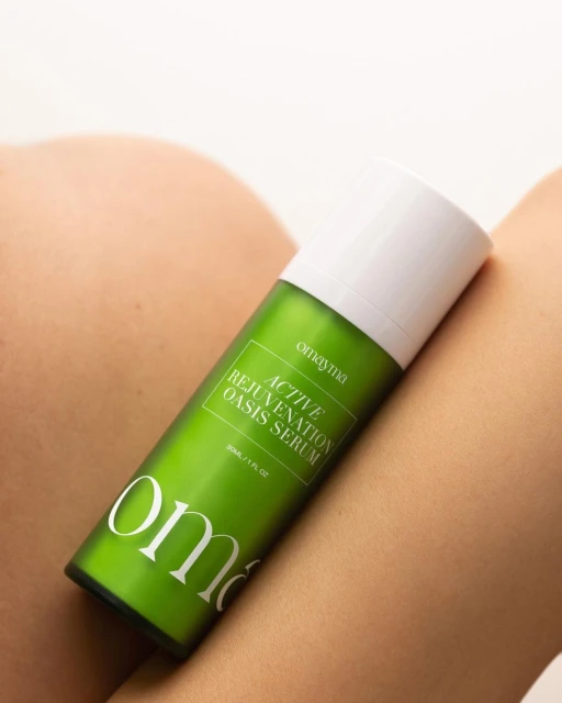 Omayna active rejuvenation oasis serum displayed against a nude background in a studio setting, highlighting the product's packaging.