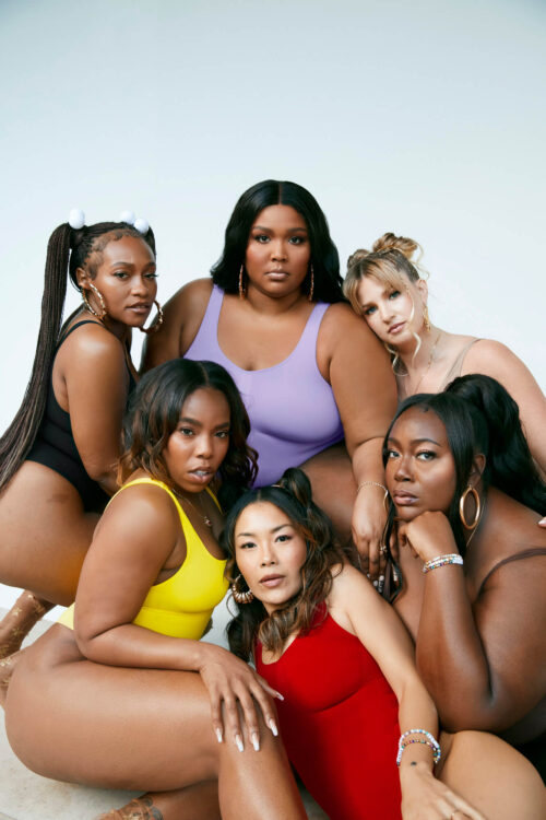 Group of six diverse female models wearing colourful swimsuits posing against a light background by Bonnie Nichoalds