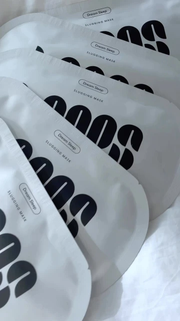 Five white packages of "Dream Sleep" slugging mask are arranged on a white surface. The packages feature black text and a minimal design.