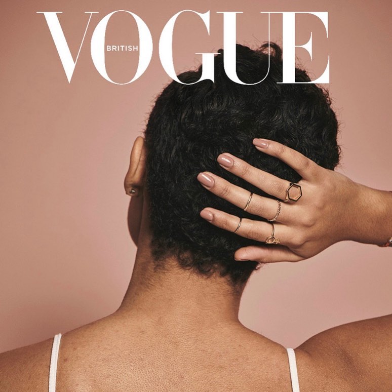 British Vogue magazine cover featuring the back of a woman's head with short dark hair, hand on head displaying multiple gold rings.