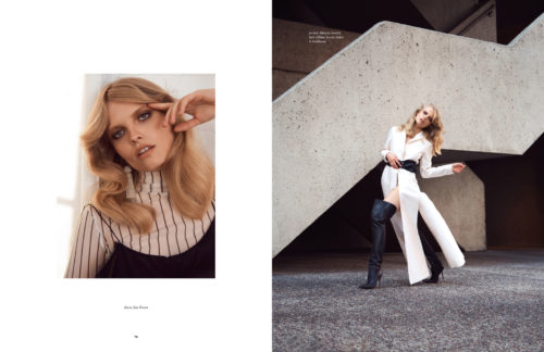 Fashion editorial shot featuring a blonde woman in a white outfit with black boots posing near a concrete staircase for a fashion magazine spread.