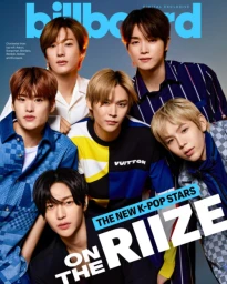 Group portrait of six young male k-pop artists posing closely together against a smooth gradient background for a digital magazine cover.