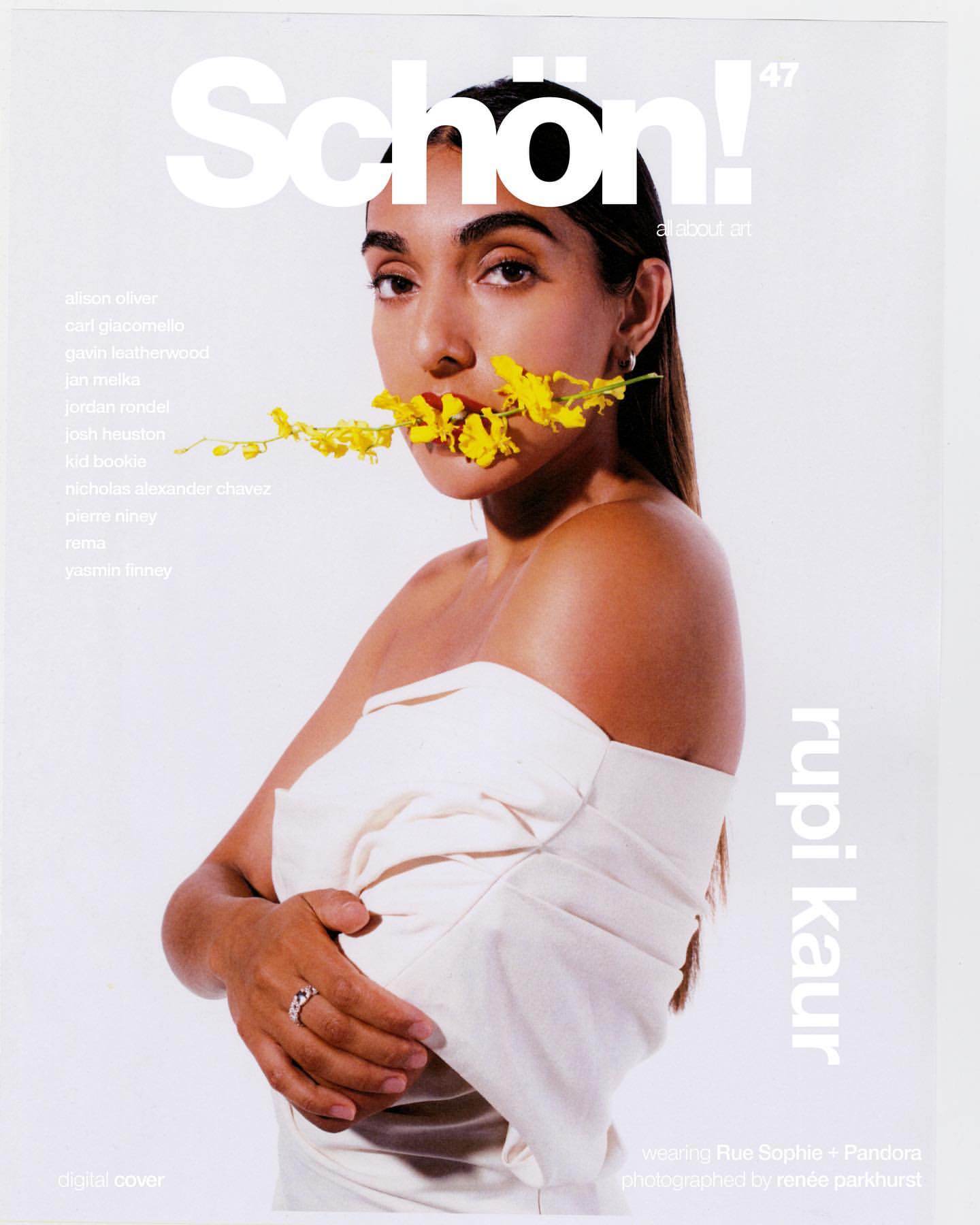 Schön! magazine cover featuring a portrait of Rupi Kaur holding yellow flowers in her mouth, styled in an off-shoulder white dress on white background.