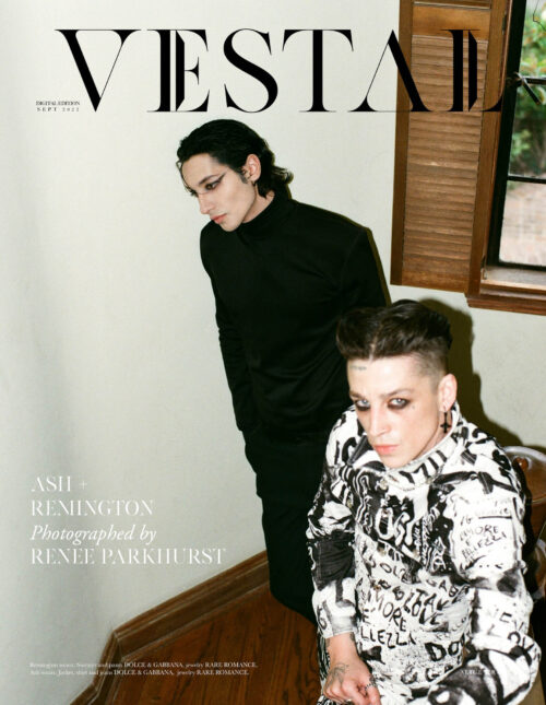 Two adult humans in stylish black and white clothing on a magazine cover. Indoor scene, medium shot, soft lighting.