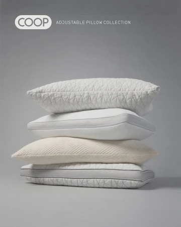 A stack of four Coop adjustable pillows on a gray background. Pillows have textures and gray trim. Coop logo is visible at top left.