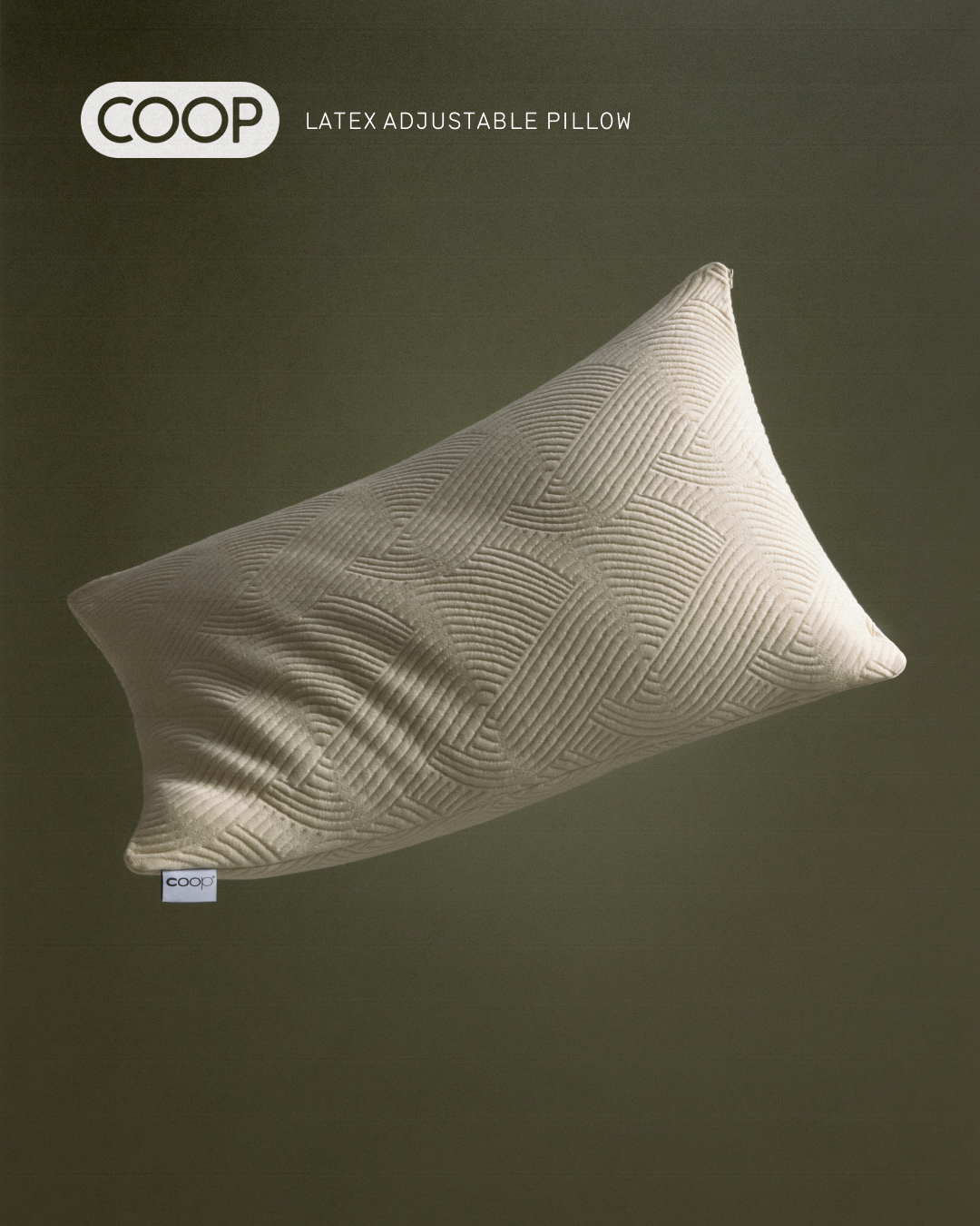 Beige Coop latex adjustable pillow with a geometric pattern is against a green backdrop in a studio product shot for advertising.