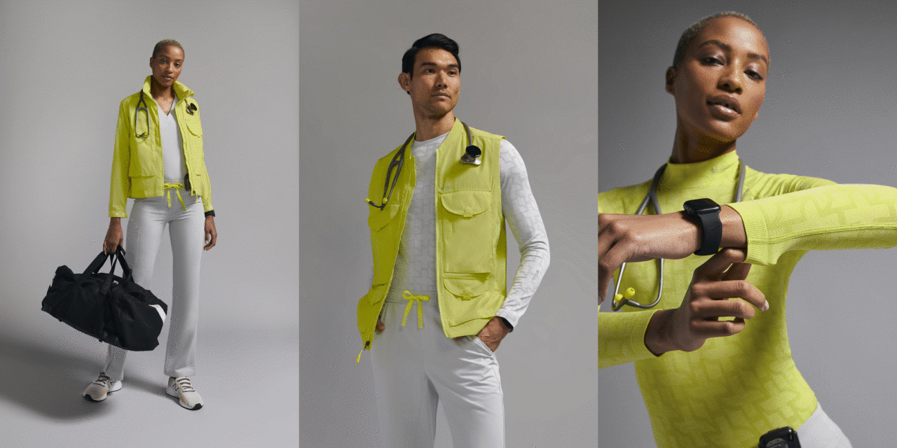 Medical professionals in yellow vests and jackets in a studio setting, wearing grey scrubs and athletic shoes and carrying a duffel bag.