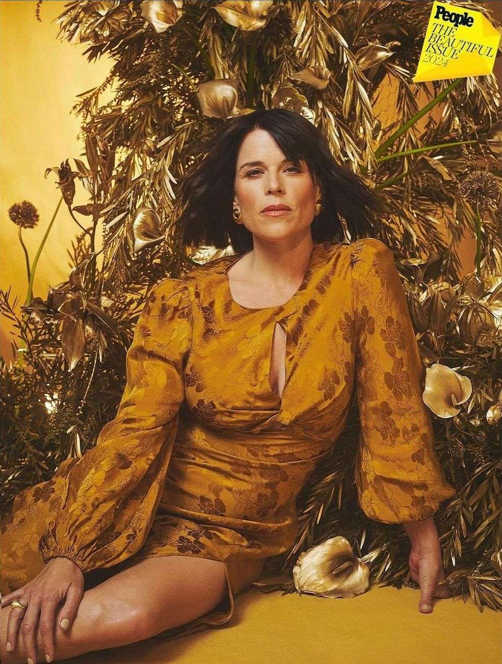Neve Campbell graces the cover of People's The Beautiful Issue 2024, adorned in a golden patterned dress against a metallic floral backdrop.